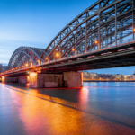 Der Kölner Dom am Rhein mit Hohenzollernbrücke am Abend