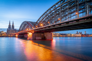 Der Kölner Dom am Rhein mit Hohenzollernbrücke am Abend